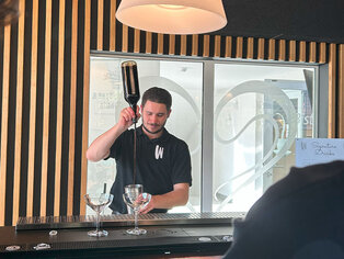 Abbildung eines Barkeepers beim Cocktails mixen.