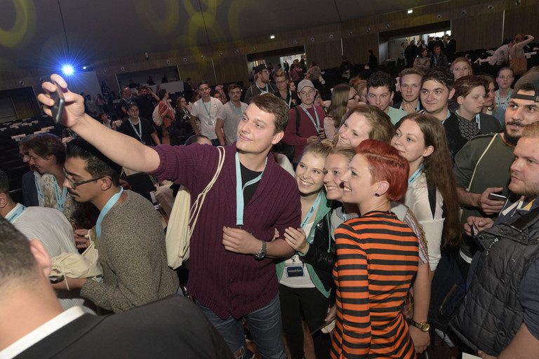 Abbildung von mehreren Personen beim Selfies machen.