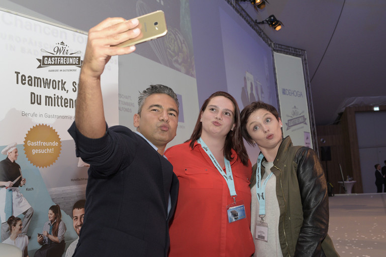 Abbildung von drei Personen beim Selfies machen.