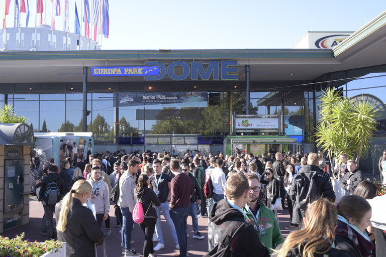 Abbildung einer Menschenmenge vor einem großen Gebäude mit der Aufschrift Europa-Park Dome.
