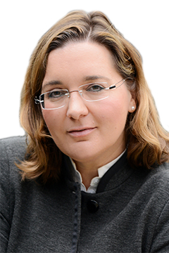 Abbildung einer Person mit schulterlangem Haar, Brille und grauer Jacke. Abbildung einer Person mit schulterlangem Haar, Brille und grauer Jacke.