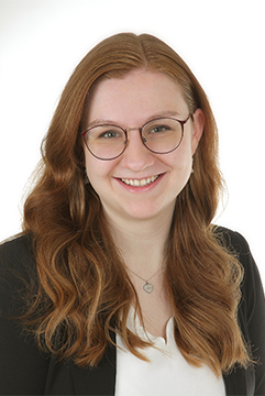 Abbildung einer Person mit langen, welligen Haaren in schwarzem Blazer und weißem Shirt.